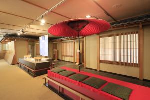 日光Yumori Kamaya的一间设有红色床和大吊灯的房间