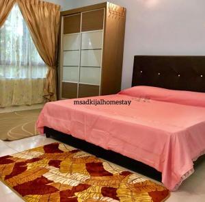 甘榜甘马挽HOMESTAY MSA D'KIJAL的一间卧室配有一张带粉红色床单和地毯的床。