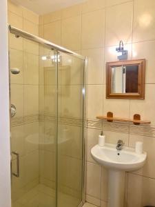 卡文Carraig House的一间带玻璃淋浴和水槽的浴室