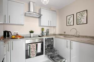 亨顿Spacious & Cosy, Netflix, Parking, Colindale Station的厨房配有白色橱柜和洗碗机。