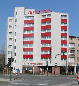 埃森埃森城市酒店的一座白色的大建筑,上面有红色的窗户和标志