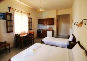 霍里顿图丽曼纳奇旅馆的带两张床的房间和带桌子的厨房