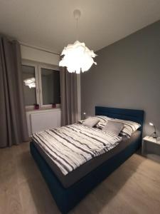 弗热希尼亚Apartament Września II的一间卧室配有一张带吊灯的大床