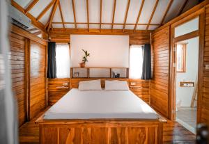 吉利特拉旺安Rascal House Gili Trawangan的木墙客房内的一张大床