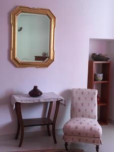 Borgofranco dʼIvrea拉瑞姆皮赤那住宿加早餐旅馆的一面墙面上的镜子,旁边是椅子和桌子