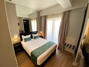 里斯本Lisbon City Hotel by City Hotels的一间卧室设有一张床和一个大窗户