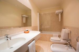 阿威罗芬尼萨酒店的浴室配有盥洗盆、卫生间和浴缸。