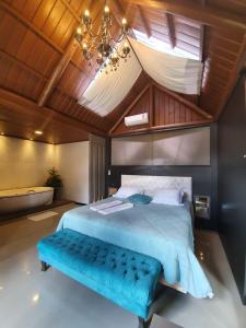 圣若泽杜斯皮尼艾斯布干维尔生态旅馆的一间卧室配有一张大床和蓝色长凳