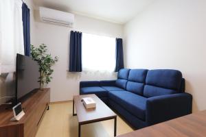 大阪5 minutes Shin-Osaka 3的客厅配有蓝色的沙发和电视