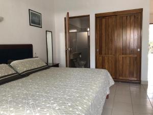 科利马Hotel San Joaquin SA de CV的一间卧室配有一张床和一扇木门