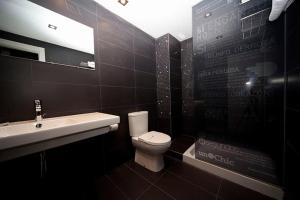 韦斯卡Hospedium Hostal Un Punto Chic的浴室配有白色卫生间和盥洗盆。