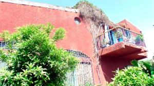 达喀尔Fabuleuse Villa Keur Bibou的一座红色的建筑,旁边设有楼梯