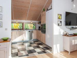 Sønder Nissum8 person holiday home in Ulfborg的厨房设有木制橱柜和 ⁇ 格地板。