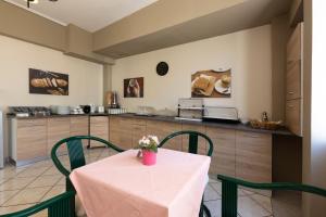 比雷埃夫斯菲隆酒店的厨房配有带绿色椅子的桌子和柜台。