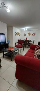 阿里卡DEPARTAMENTO POR DÍA EN LA CIUDAD DE ARICA.的客厅配有红色的沙发和桌子