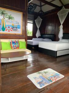 苏加武眉Arya's Surf Camp的一间客房配有两张床、一张沙发和地毯。