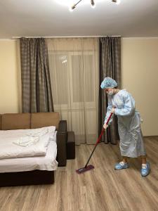 乌日霍罗德Центр міста! Затишні квартири в новобудові!的女人正在用拖把打扫房间