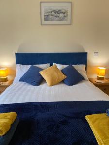 马汉莱斯Moelfre B&B的卧室配有蓝色和白色的床和枕头