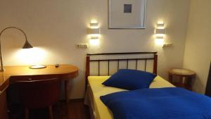 罗斯多夫赫司科希豪斯酒店的一间卧室配有一张床和一张带蓝色枕头的书桌