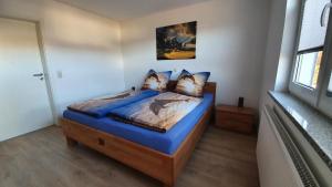马瑟尔贝格Schnetter Hummel, Apartment 1的一间卧室配有一张带蓝色床单和枕头的床。