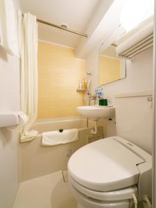 东京池袋站北口乐活超级酒店的白色的浴室设有卫生间和水槽。