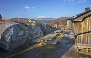 里克斯格伦森Arctic Lodge的建筑物附近的甲板上的一排野餐桌