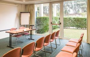 圣玛丽亚大德费拉波尔图扎欧陆公园宜必思酒店 的一间会议室,配有椅子、桌子和白板