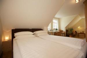 欧巴德伍斯图Schimmels Pension的卧室配有白色的床单和枕头