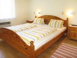 沃尔特湖畔韦尔登Apartments Roemerschlucht的一张带白色床单和枕头的大型木制床