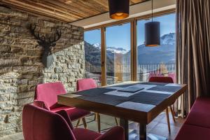 索尔登Chalets - The Peak的一间带桌子和粉红色椅子的用餐室