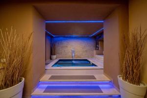 奥尔比亚全景酒店的蓝色灯光的客房内的按摩浴缸
