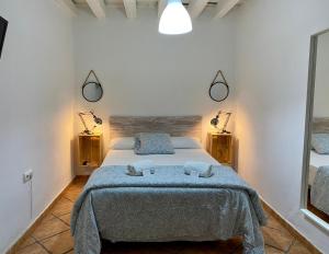 加的斯Pensión La Cantarera的一间卧室配有一张床,上面有两条毛巾