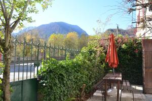 VicdessosLa maison d'Inca的围栏旁边的桌子上摆着一把红伞