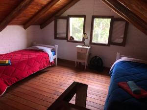 拉帕洛马La Ranita Negra的一间卧室设有两张床和两个窗户。