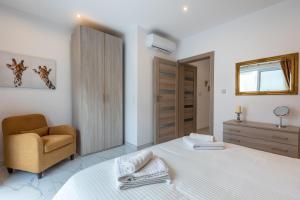 梅利哈White Sands的白色卧室配有床和椅子
