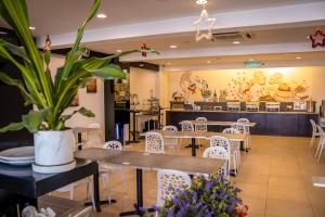 吉隆坡Prescott Hotel Bukit Bintang的一间设有桌椅和盆栽的餐厅