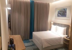 班加罗尔Holiday Inn Express & Suites Bengaluru Old Madras Road, an IHG Hotel的酒店客房配有一张床铺和一张桌子。