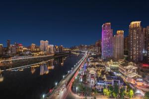 重庆漫途高空江景酒店（解放碑洪崖洞夜景店  ) 的夜晚的城市,河流和建筑