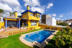 林孔-德拉维多利亚Milestone House的一座黄色房子,在院子里设有一个游泳池