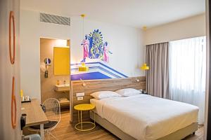 雅典ibis Styles Athens Routes的酒店客房配有一张床铺、一张桌子和一张书桌。