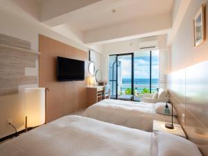 恩纳パレスインムーンビーチ的酒店客房设有两张床和一台平面电视。