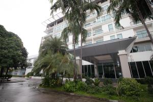罗勇Phavina Hotel Rayong SHA Extra Plus的一座棕榈树建筑