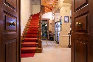 罗希姆诺帕拉齐诺帝科里纳酒店的走廊上,房子里铺着红色地毯的楼梯