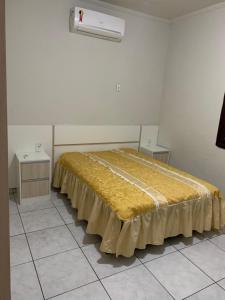 瓜鲁雅Linda casa de Veraneio的一张大床,房间带两张桌子