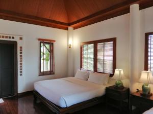 慕斯Casa Khaoyai Bed&Breakfast的卧室配有白色的床和2扇窗户。