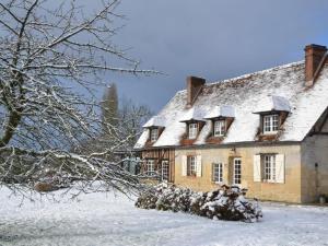 利雪Maison d'Hôtes la Bihorée的院子内有雪盖屋顶的房子