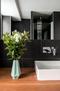 慕尼黑Mozart Apartment München的浴室设有白色水槽和花瓶