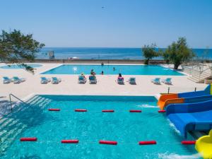 安吉PEARL BEACH RESORT - Hills & Villas的一个带水滑梯和海滩的游泳池