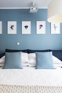 慕尼黑Mozart Apartment München的一间卧室拥有蓝色的墙壁,配有一张带蓝色枕头的床。