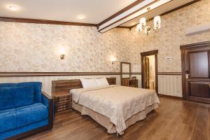 索契Villa Polianna的一间卧室配有一张床和一张蓝色的沙发